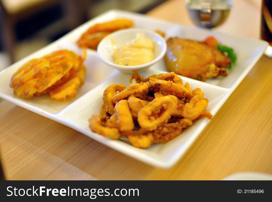 Fried squid rings and chicken wings with salad dressing