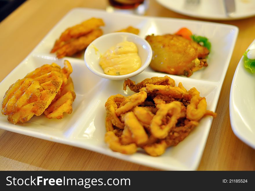 Fried squid rings and chicken wings with salad dressing