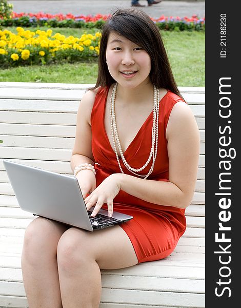 Girl working on laptop outdoor in park