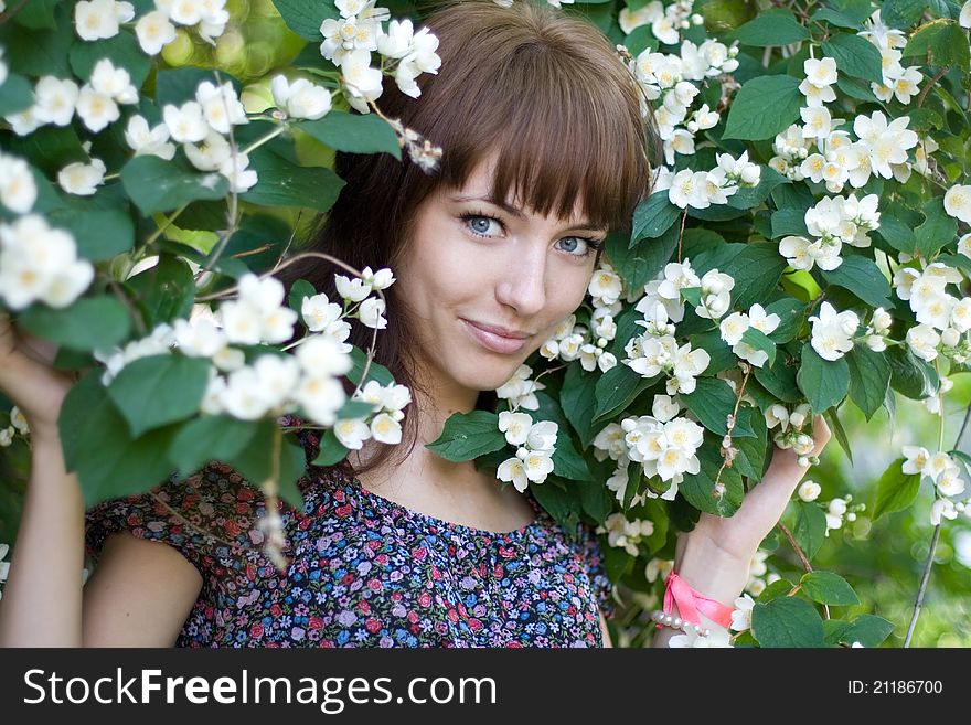 Smiling Girl Standing Among Flowers