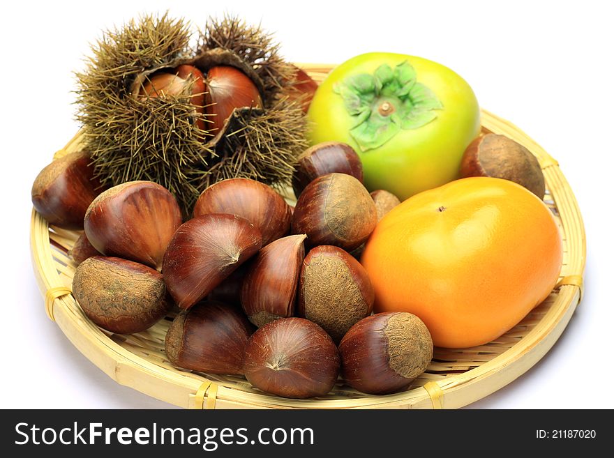 I put a persimmon and a chestnut in a colander and I took it in a white background. I put a persimmon and a chestnut in a colander and I took it in a white background.