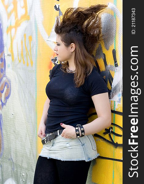 Punk girl walking outdoor near graffiti wall