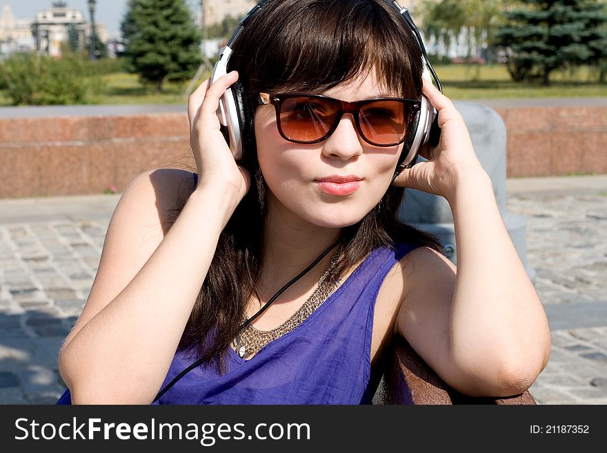 Girl listening music in headphones in park