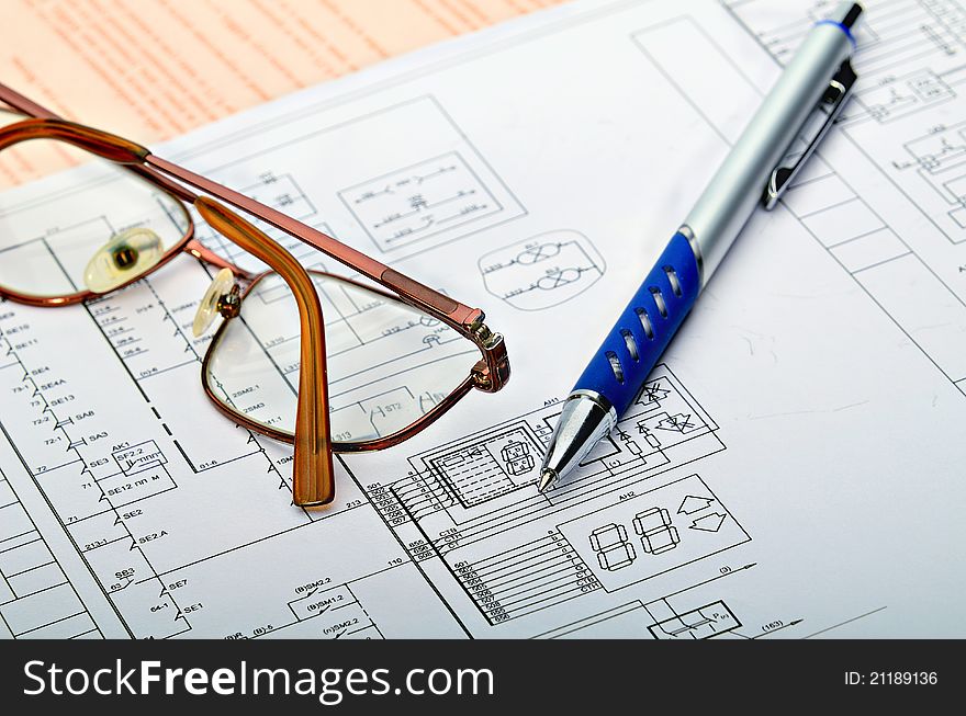 The electric scheme and pen on a table