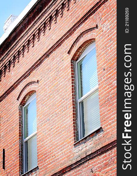 A view of the details of an old brick wall with windows. A view of the details of an old brick wall with windows.