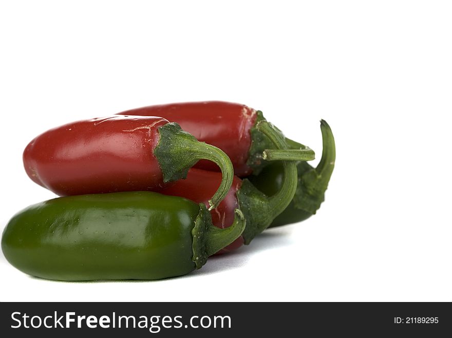 Red and green jalapeno peppers on a white background