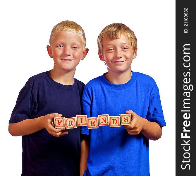 Two young boys who are friends holding letter wood blocks spelling Friends. Two young boys who are friends holding letter wood blocks spelling Friends.