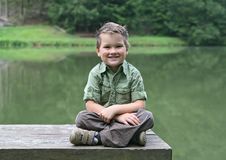 Boy Cross-legged On A Bench At Pond Royalty Free Stock Photos Boy Cross-legged On A Bench At Pond Royalty Free Stock Photos