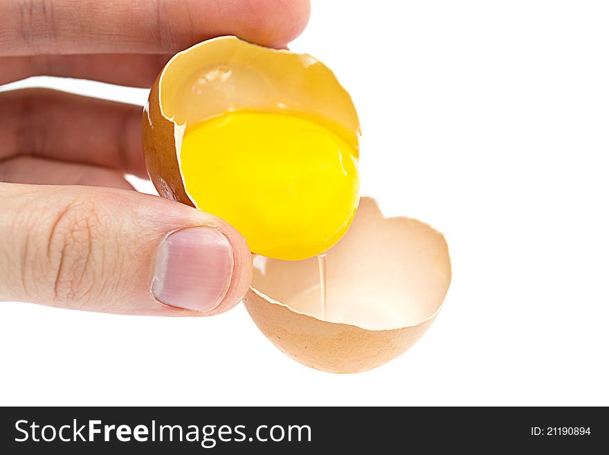 Hand with broken egg on a white background