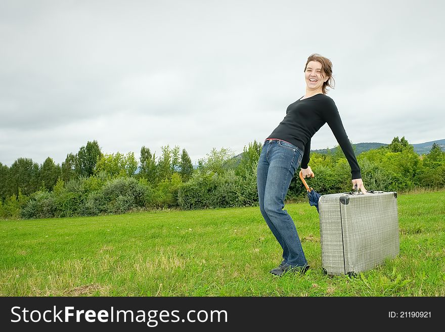 Young woman having fun with a heavy suitcase. Young woman having fun with a heavy suitcase