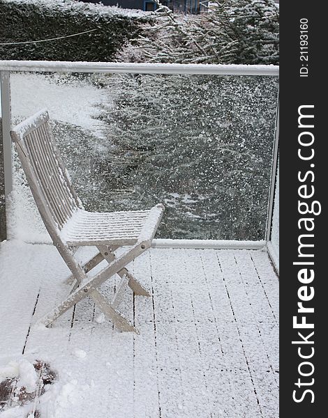 Snow on wooden chair. Winter time