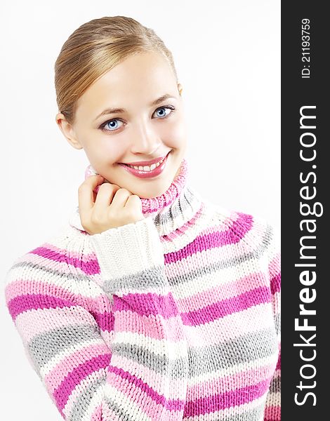 Beautiful girl in colored sweater on a light background