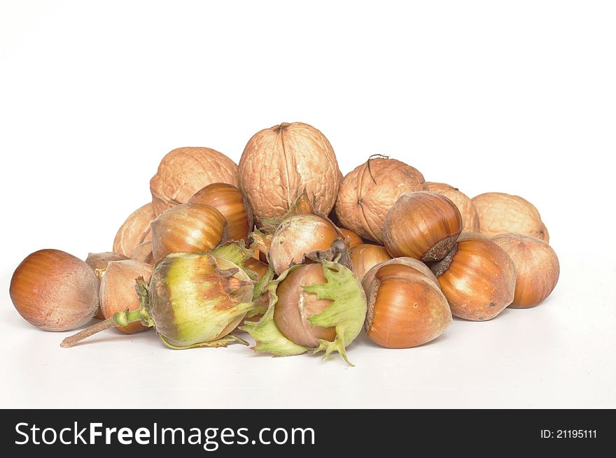 Hazelnuts and walnuts on white background