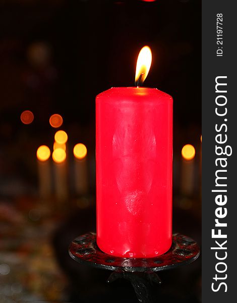 The image of a burning candle under the blurred background