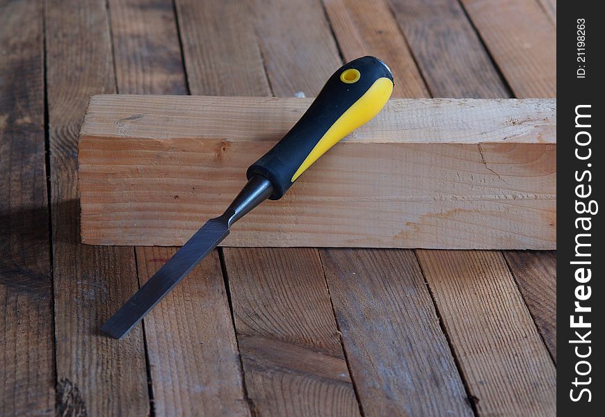 Chisel on the wood. Wooden planking background.