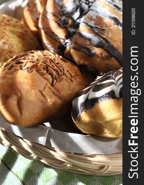 Delicious bread in a wooden basket illuminated with dramatic morning light. Great images for food and beverages article or any design involving food and drinks. Delicious bread in a wooden basket illuminated with dramatic morning light. Great images for food and beverages article or any design involving food and drinks.