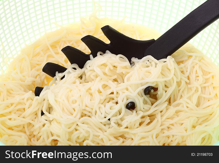 Noodles in green colander isolated on a white background. Noodles in green colander isolated on a white background
