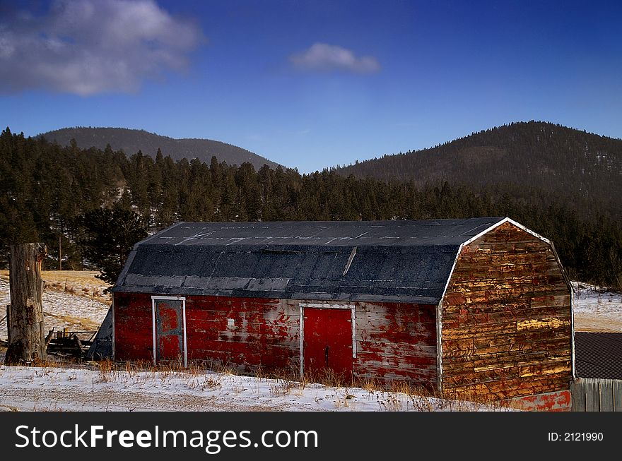 Old red American barn in a snow covered scenic landscape. Old red American barn in a snow covered scenic landscape