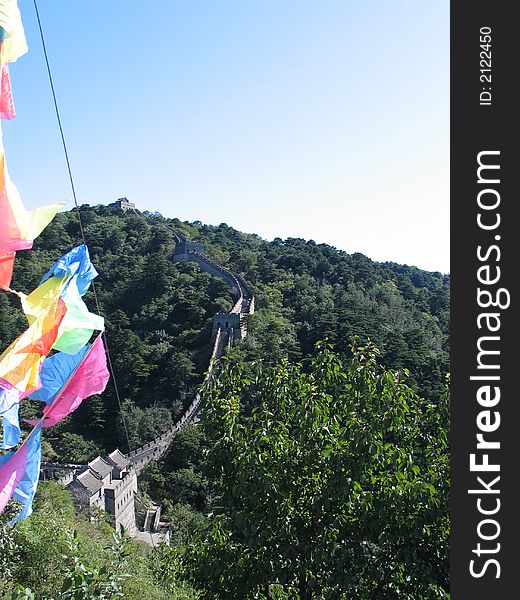 Brightly coloured flags flying over the Great Wall of China at Mutianyu