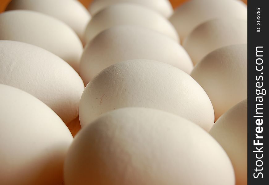 Heap of white eggs with focused detail of surface of one egg. Heap of white eggs with focused detail of surface of one egg