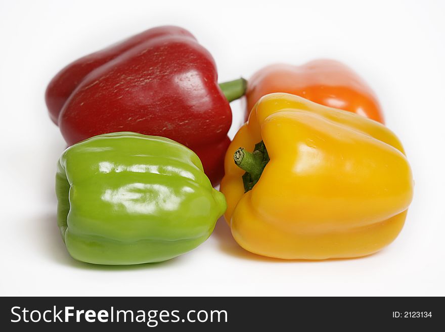 Four colorful peppers on white background