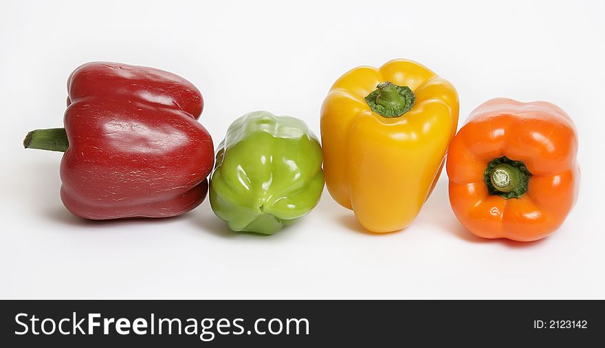 Four colorful peppers on white background