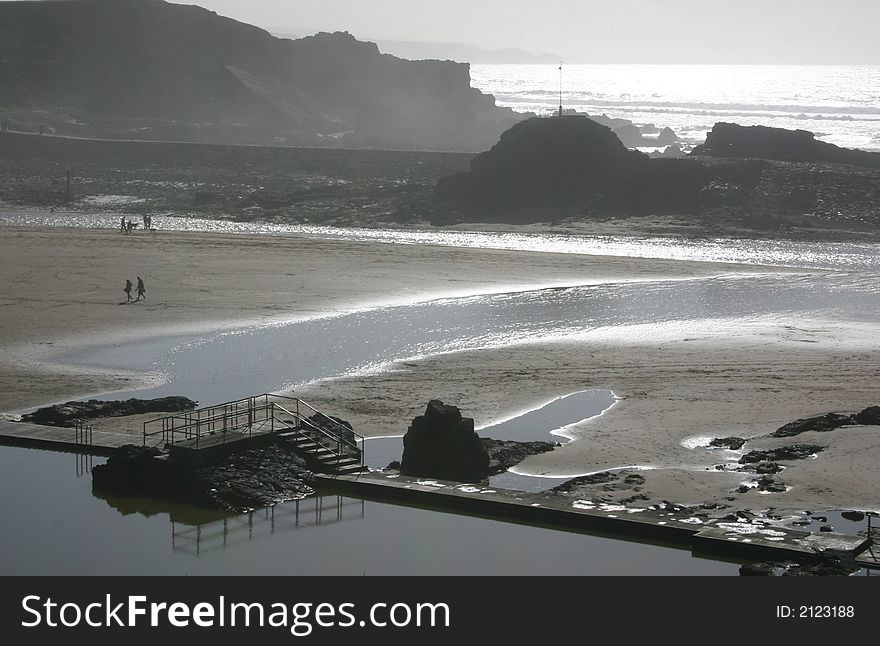 Misty beach scene with a old swimming pool in  the forefront