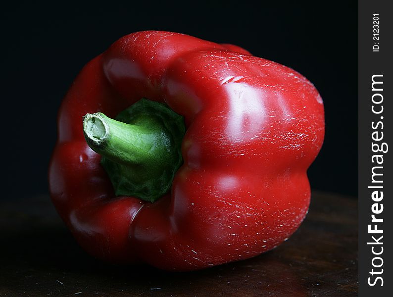 One red pepper on black background