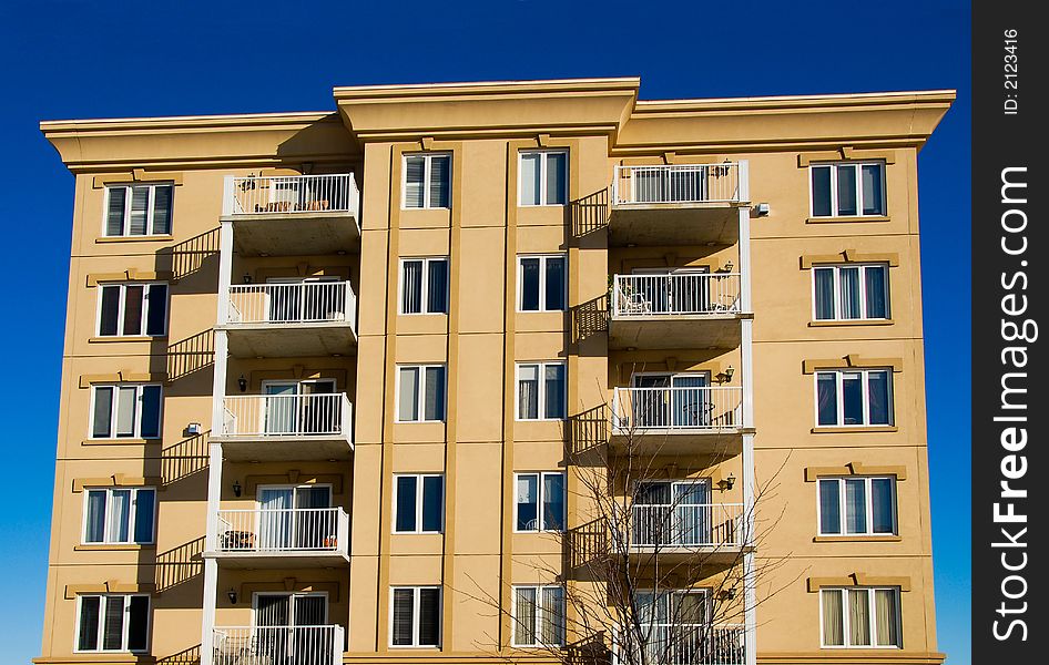 Modern beige and brown apartment condos on blue sky