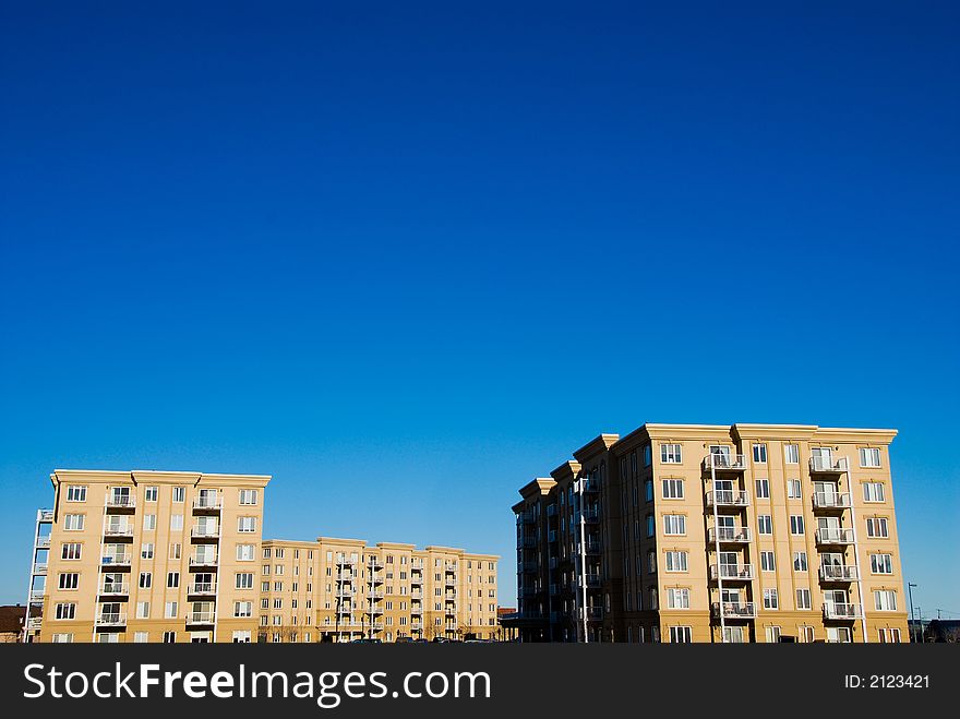 Modern beige and brown apartment condos on blue sky. Modern beige and brown apartment condos on blue sky