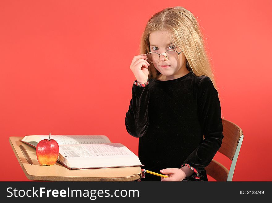 Shot of a little girl sitting in school desk