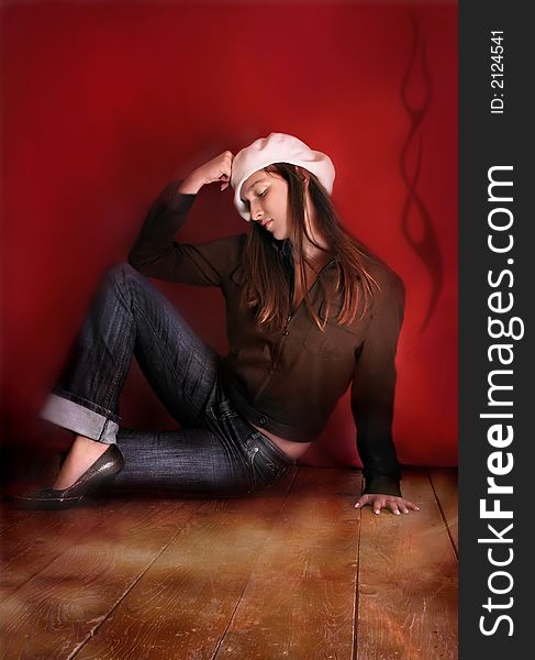 Young brunette with hat sitting on floor. Young brunette with hat sitting on floor