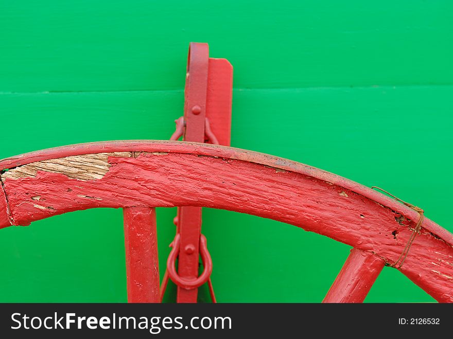 Close up of a green wagon with red wheels.