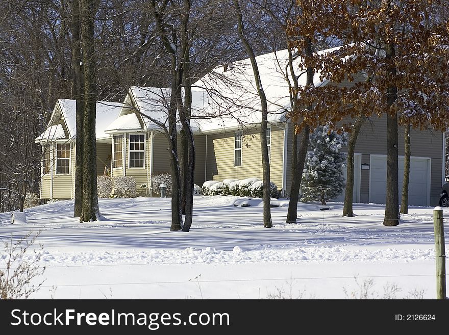 One story home with snow covered lawn in a woodsy setting. One story home with snow covered lawn in a woodsy setting.