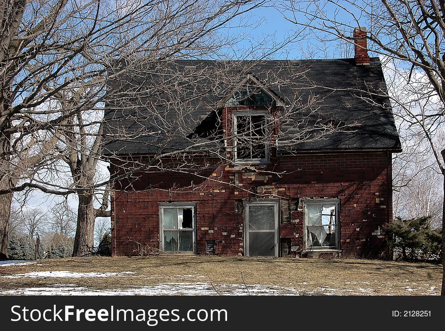 Old farm house sinking into the ground because of foundation damage. Old farm house sinking into the ground because of foundation damage