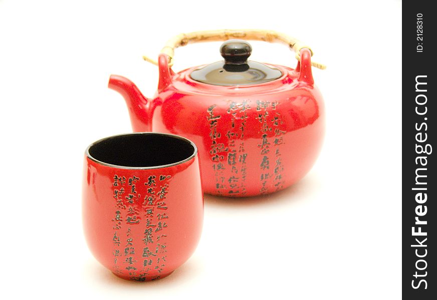 Red Chinese teapot with cup from service for tea leaves of green tea