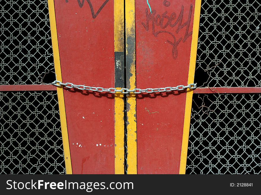 Locked, metal chain across red door