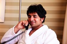 Man In Bathrobe Talking On A Phone Stock Image