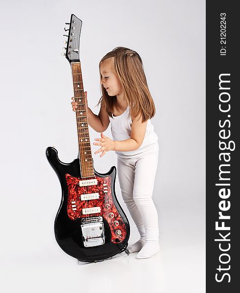 Small child hold red acoustic guitar. Music