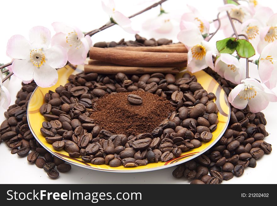 Coffee beans with cinnamon sticks and flowering branch