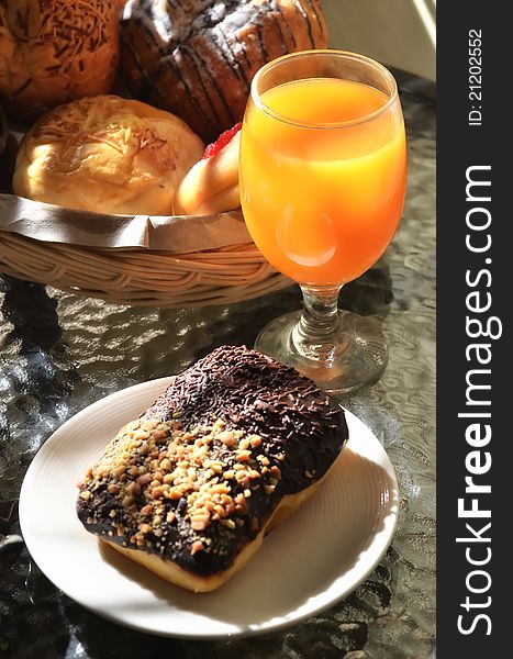 Delicious Chocolate bread  served as breakfast and orange juice as the drinks. More bread in the basket on background. Great images for food and beverages article or any design involving food and drinks. Delicious Chocolate bread  served as breakfast and orange juice as the drinks. More bread in the basket on background. Great images for food and beverages article or any design involving food and drinks.