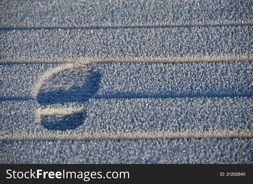 Footprint on the icy walkway. Footprint on the icy walkway