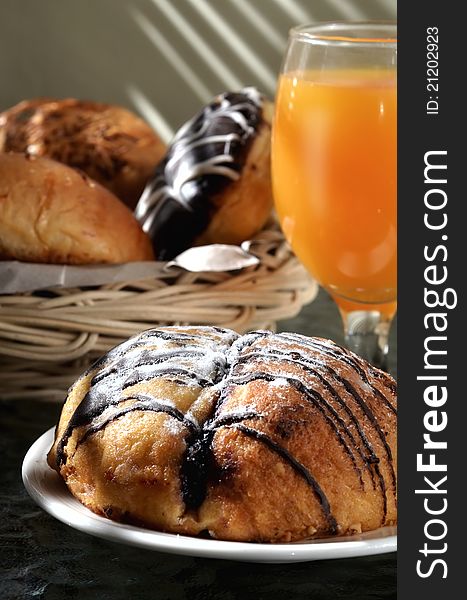 Delicious Chocolate bread  served as breakfast and orange juice as the drinks. More bread in the basket on background. Great images for food and beverages article or any design involving food and drinks. Delicious Chocolate bread  served as breakfast and orange juice as the drinks. More bread in the basket on background. Great images for food and beverages article or any design involving food and drinks.