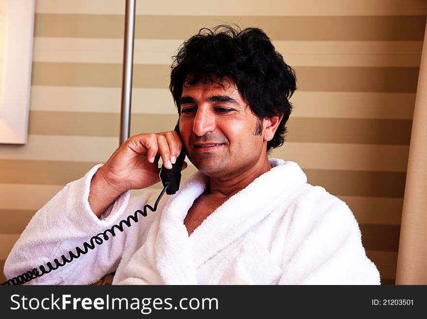 Man in bathrobe talking on a phone