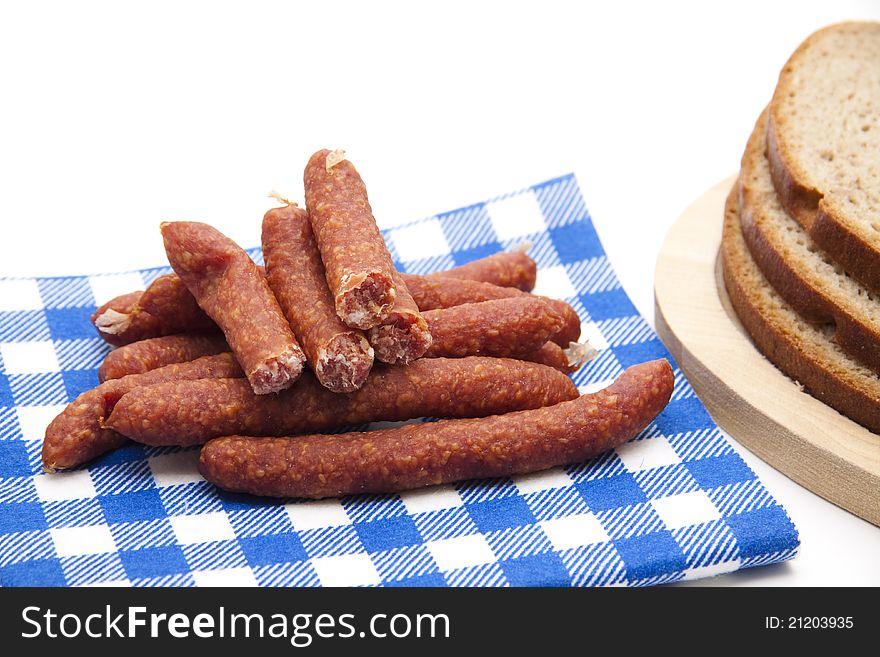 Mead sausages and bread on wooden plate with napkin. Mead sausages and bread on wooden plate with napkin