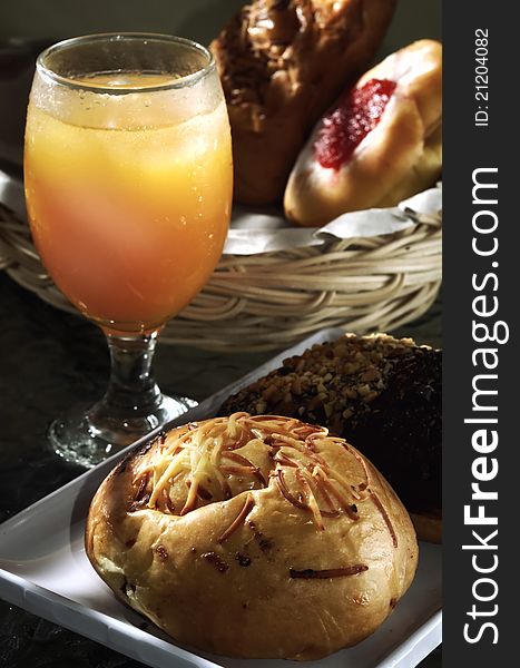Delicious Chocolate and cheesed bread served as breakfast and orange juice as the drinks. More bread in the basket on background. Great images for food and beverages article or any design involving food and drinks. Delicious Chocolate and cheesed bread served as breakfast and orange juice as the drinks. More bread in the basket on background. Great images for food and beverages article or any design involving food and drinks.