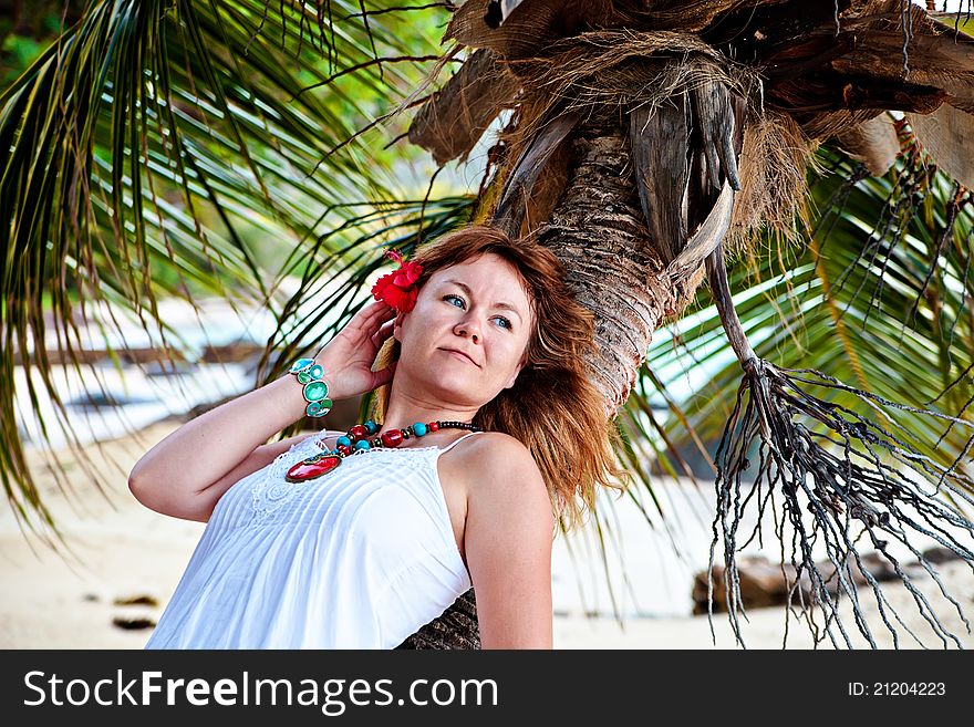 Beautiful woman with red flower in her hair resting on a palm. Beautiful woman with red flower in her hair resting on a palm