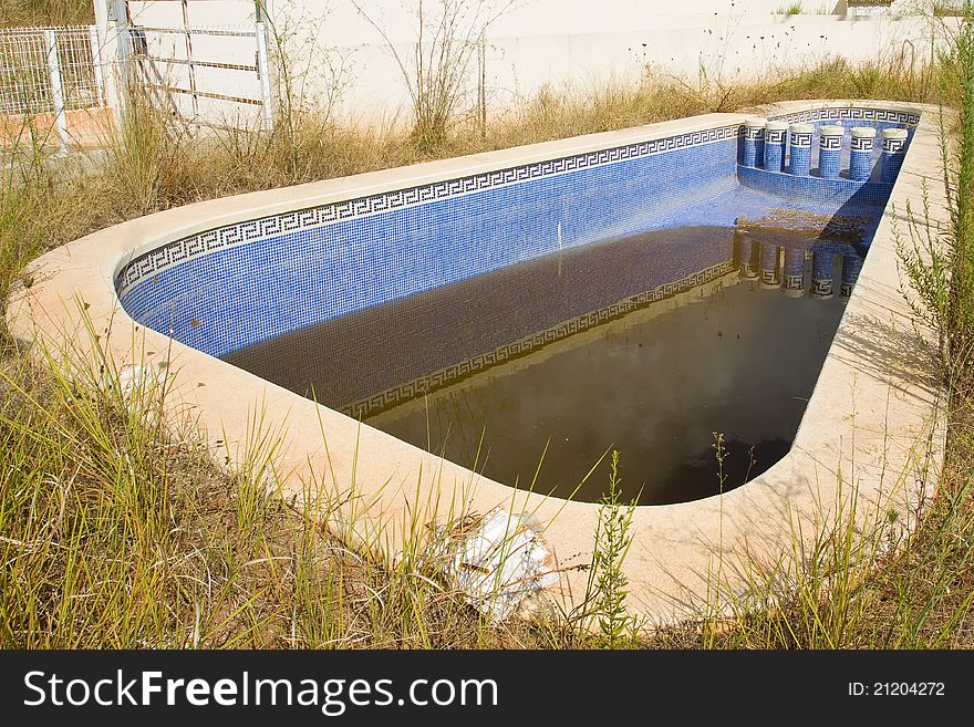 A swimming pool which has clearly been neglected. A swimming pool which has clearly been neglected