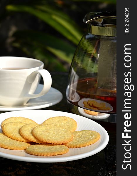 Tea served with lemon biscuits in warm afternoon light outdoor. Tea served with lemon biscuits in warm afternoon light outdoor