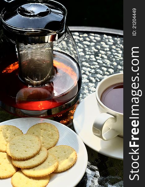 Tea served with lemon biscuits in warm afternoon light outdoor. Tea served with lemon biscuits in warm afternoon light outdoor